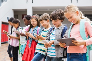 Group of kids using mobile phone and digital tablet