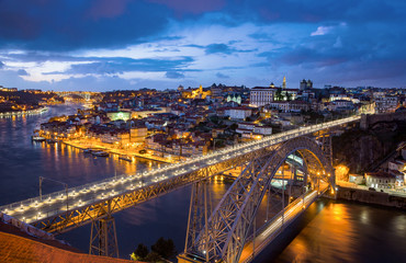 Fototapeta na wymiar View of the historic city of Porto, Portugal with the Dom Luiz bridge at dusk.