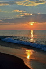 Fototapeta premium Golden Seashore Sunrise Above Breaking Waves