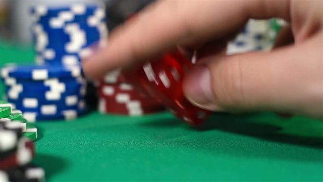 Dealer  Hand Holding Two Dice On Green Table, Close Up