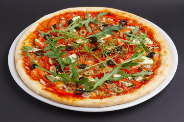 Lean pizza Margherita with cheese, arugula, tomato sauce on a white plate.