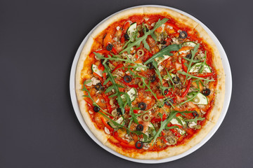 Lean pizza Margherita with cheese, arugula, tomato sauce on a white plate. Space for text.