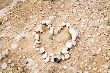 Heart made of stones on sand