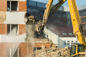 Demolitions old building in center city with heavy equipment