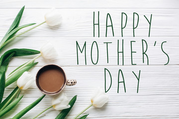 happy mothers day text sign on tulips and coffee on white wooden rustic background. stylish flat...