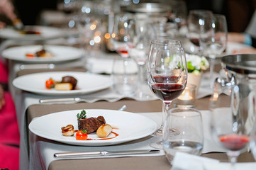 Delicious grilled steak on plate with glass of wine