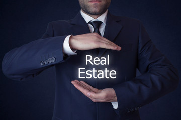 Businessman holding a Real Estate Concept