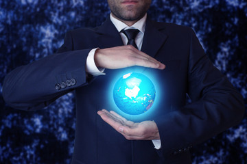 Businessman holding globe.