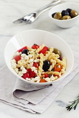 Pasta salad with fresh vegetables and feta cheese. Selective focus