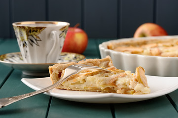 Apple tart with cup of tea and three whole apples