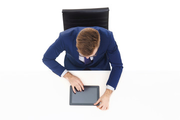 Overhead view of a handsome businessman working with tablet computer in office. Business and office concept.