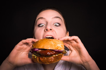 woman with a hamburger on a dark background