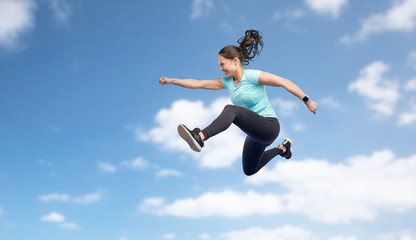 happy smiling sporty young woman jumping in sky