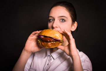 woman with a hamburger on a dark background