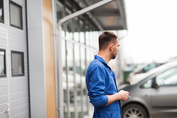 auto mechanic smoking cigarette at car workshop