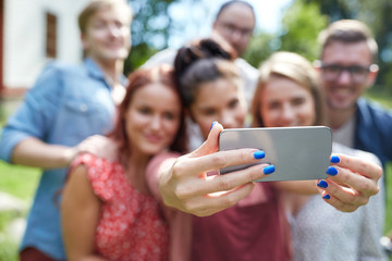 friends with smartphone taking selfie at summer