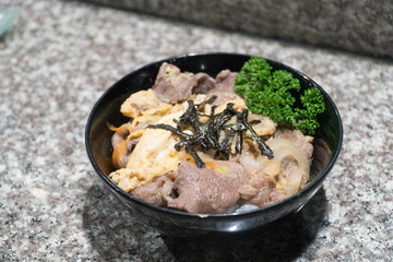 Gyudon : Japanese beef with egg rice bowl on granite table
