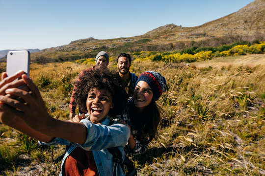 Group of friends on walk taking selfie in countryside