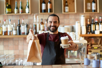 man or waiter with coffee and paper bag at bar