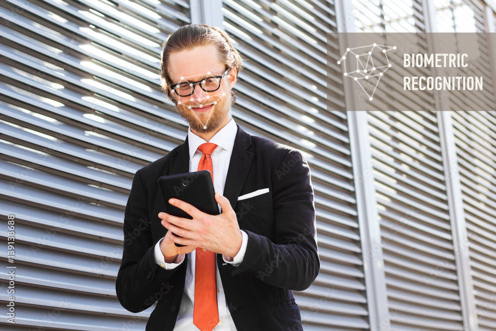 Poster a businessman with a beard and glasses smiling and looking at tablet computer. biometric recognition