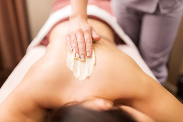 Obraz na płótnie Canvas woman having back massage with cream at spa
