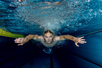 Young swimmer swimming in a pool underwater