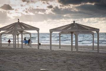 Sunset on the beach and silhouettes of surfers. Travel and vacation concept.