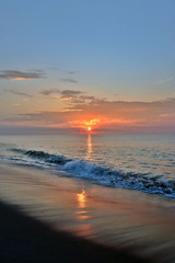 Fototapeta premium Golden Seashore Sunrise Above Breaking Waves