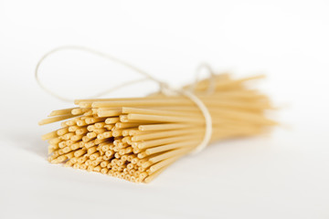 Italian bucatini pasta on white surface