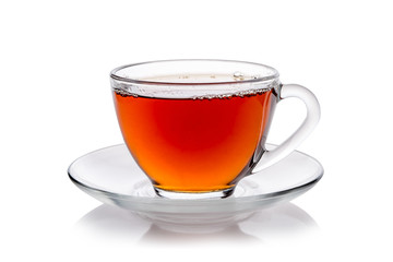 Transparent glass cup of tea and a saucer isolated on white background