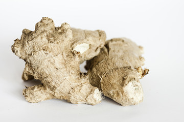 Ginger roots on white surface