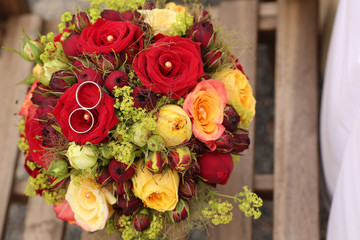 Eheringe auf einen Rosenstrauß