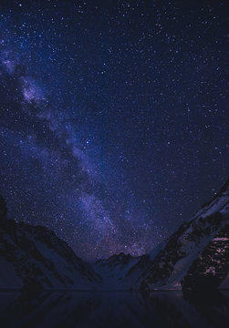 View of stars in night sky above mountains