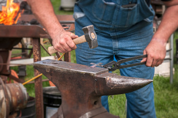 Blacksmith Hammers on Metal Cross