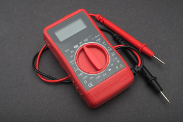 Red multimeter on a black background.