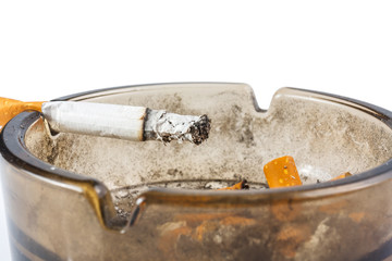 Close up of cigarette in ashtray on white background