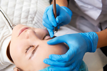 Permanent make-up wizard makes eyebrow correction procedure.