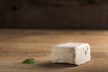 Cube of yeast on wood with copy space