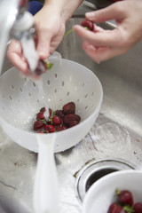 Strawberries being washed in sink