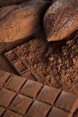 Chocolate bar, candy sweet, cacao beans and powder on wooden background
