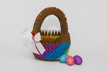 Red-yellow 3d origami Easter basket with colored eggs