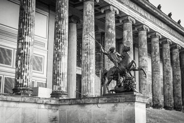The pillars of the old museum on the museum island in Berlin, center with the lion fighter statue, Germany black and white