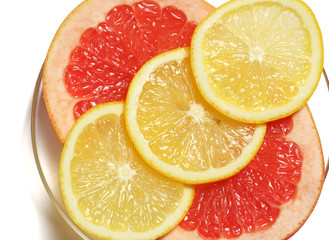 Slices grapefruit and lemon on white