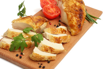 Grilled chicken fillet wit tomato on plate on wood background
