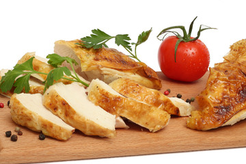 Grilled chicken fillet wit tomato on plate on wood background