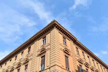 The corner of an ancient Baroque marble building in Turin, Italy, with blue sky in the background.