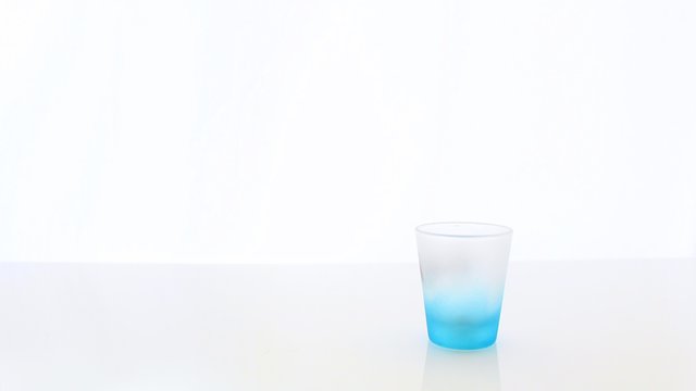 Light Blue Shotglass Cup with a Blurry White Background