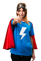 Pretty superhero girl making gun gesture