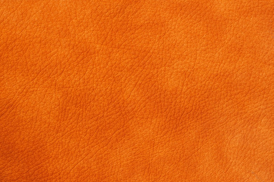 Texture of genuine leather close-up, cowhide, orange. For natural, artisan backgrounds, substrate composition use, vintage design