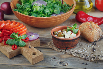 Ingredients for vegetables salad on a wooden background.